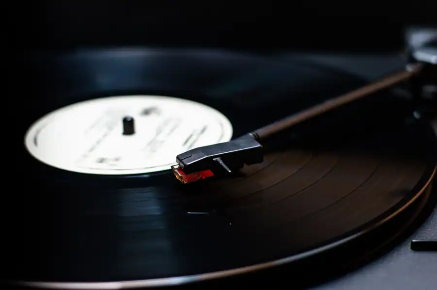 Detailed close-up of a classic vinyl record player spinning a vintage record, emphasizing warm sound.